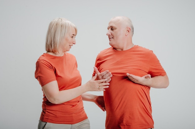 hombre y mujer con camisetas naranjas de fondo blanco