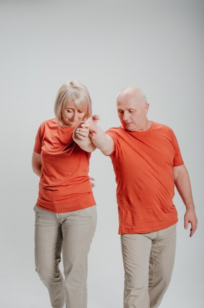 hombre y mujer con camisetas naranjas de fondo blanco