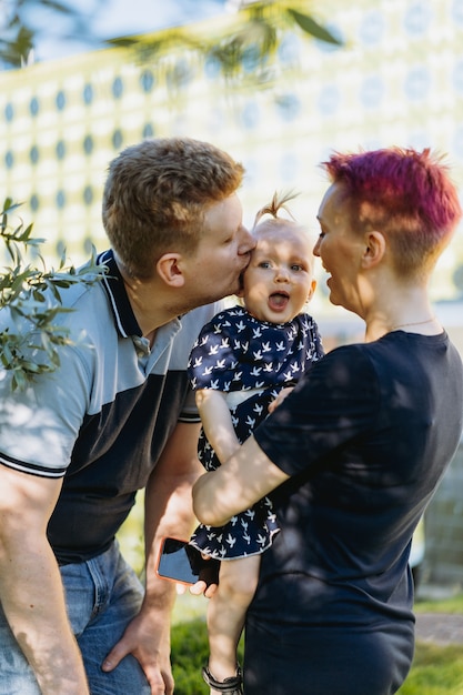 Hombre y mujer caucásicos padres de niña besando a su hija