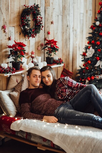 Hombre y mujer celebran la Navidad juntos en un ambiente cálido en casa