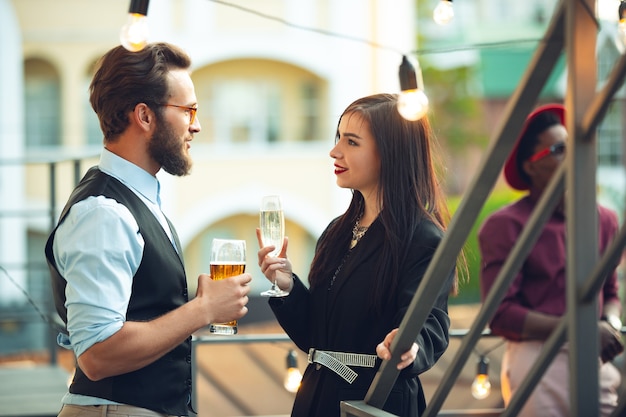 Hombre y mujer celebrando, se ven felices, tienen una fiesta corporativa en la oficina o en el bar