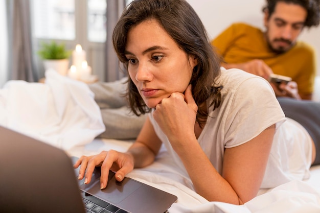 Hombre y mujer comprobando sus dispositivos en interiores