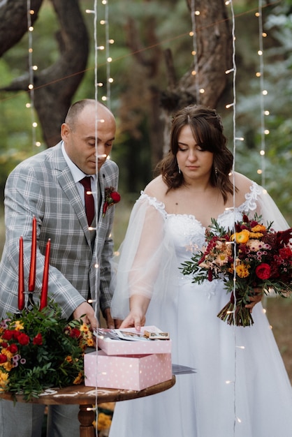 El hombre y la mujer se comprometieron en el bosque de otoño en la ceremonia de boda decorada