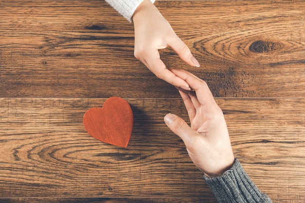 Hombre y mujer con corazón pequeño en madera