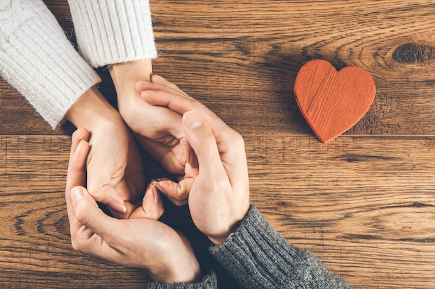 Hombre y mujer con corazón pequeño en madera