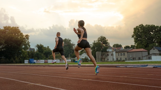 Foto hombre y mujer corriendo en pista tiro completo