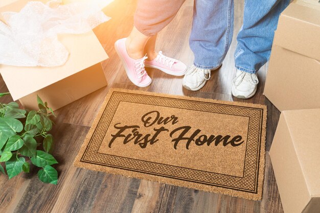 Hombre y mujer desempaquetando cerca de nuestra primera casa estera de bienvenida mudando cajas y plantas