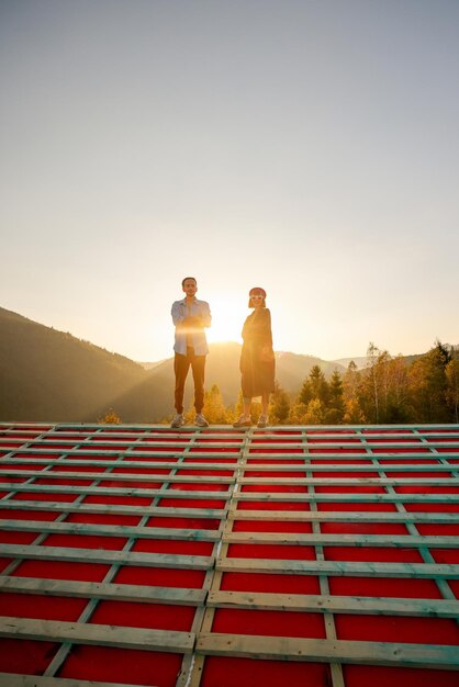 Hombre y mujer disfrutan de una hermosa puesta de sol en las montañas