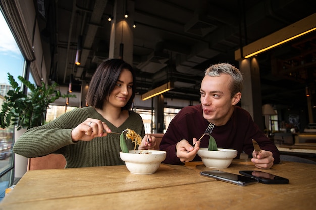 Hombre y mujer disfrutando de comida asiática