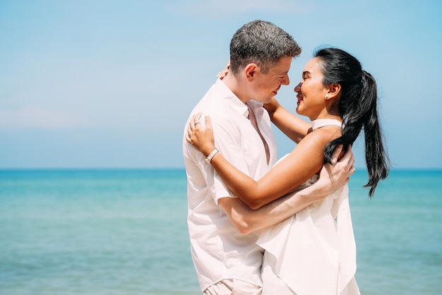 Hombre y mujer disfrutando de un viaje de luna de miel en la playa