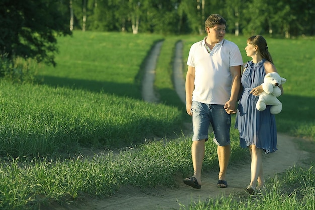 hombre y una mujer embarazada en el campo en el camino felicidad