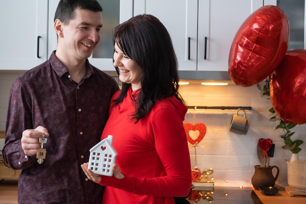 Hombre y mujer enamorados fecha en casa en la cocina con llaves de la casa Día de San Valentín pareja feliz historia de amor Amor nido hipoteca reubicación comprar vivienda inmobiliaria para familia joven