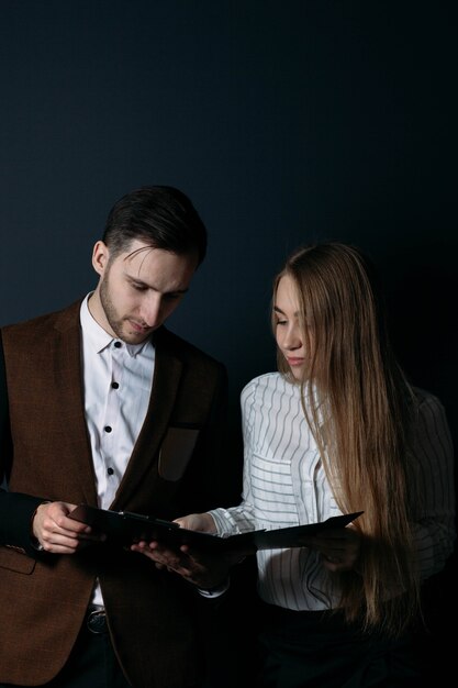 El hombre y la mujer del equipo de negocios de la pareja joven discuten el concepto de los colegas del proyecto