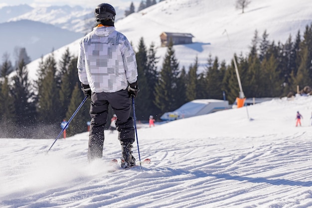 Hombre y mujer esquiando y haciendo snowboard en la estación de esquí de las montañas