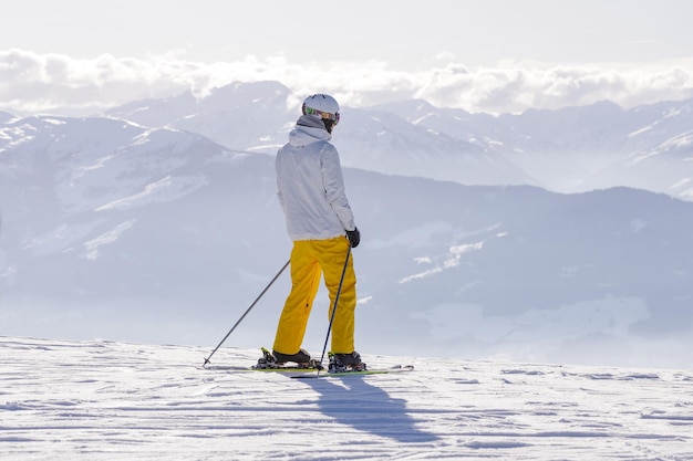 Foto hombre y mujer esquiando y haciendo snowboard en la estación de esquí de las montañas