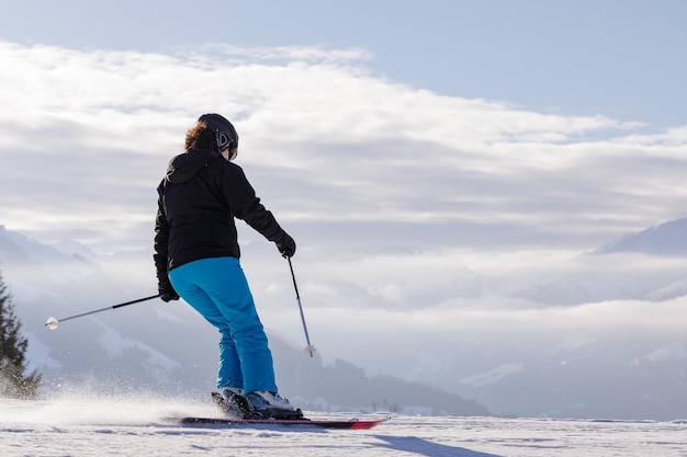 Hombre y mujer esquiando y haciendo snowboard en la estación de esquí de las montañas