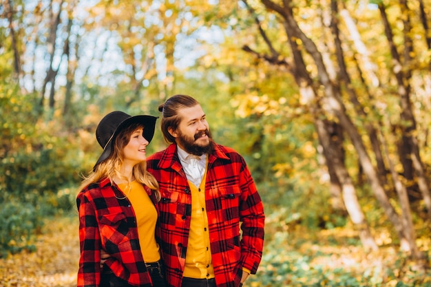 Hombre y mujer están caminando en el bosque de otoño