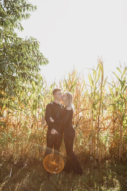 El hombre y la mujer están cerca del maíz. Concepto de amor y felicidad. Pareja en campo. Otoño.