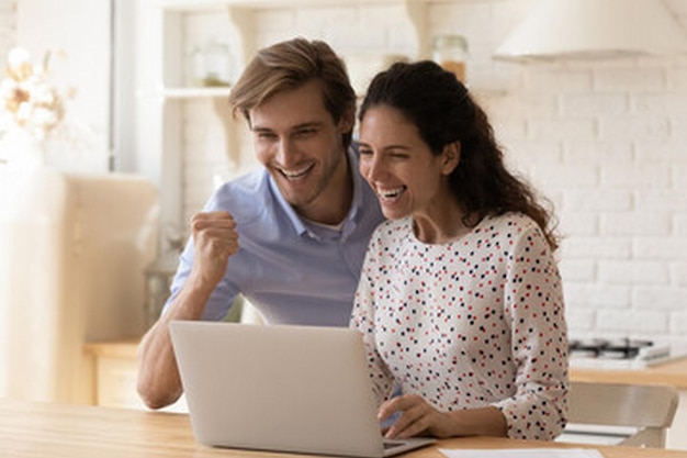 un hombre y una mujer están mirando una computadora portátil