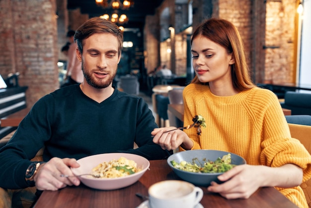 Un hombre y una mujer están sentados en una mesa en un restaurante comida deliciosa comida que sirve platos