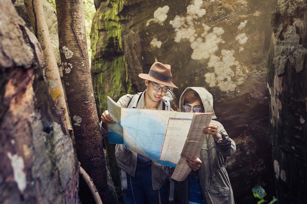 El hombre y la mujer están usando el mapa para ver rutas de senderismo.