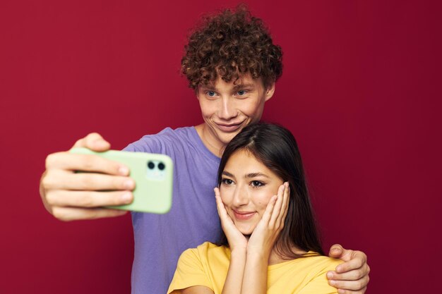 Foto hombre y mujer estilo moderno emociones diversión teléfono fondo rojo