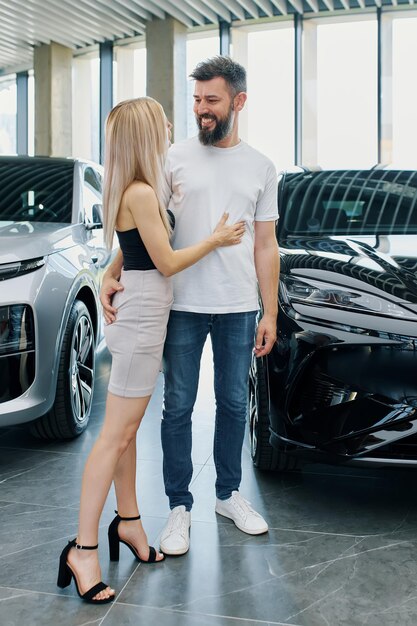 Un hombre y una mujer europeos negocian la compra de un coche nuevo en un concesionario de automóviles