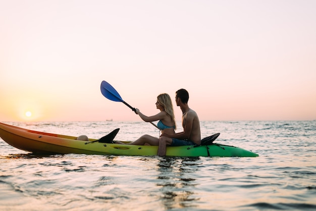 hombre y mujer explorando el océano en un kayak