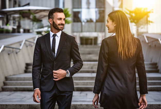 El hombre y la mujer felices caminando en el centro de negocios