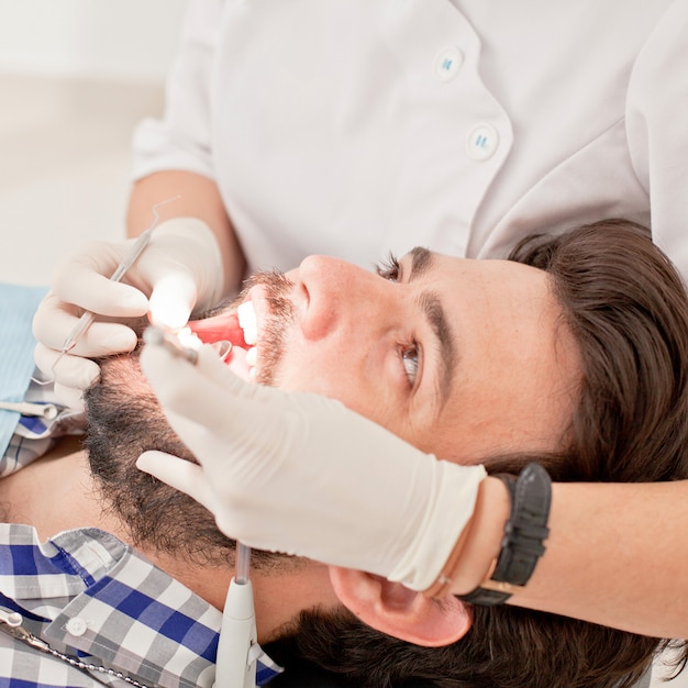 Hombre y mujer felices jovenes en un examen dental en el dentista