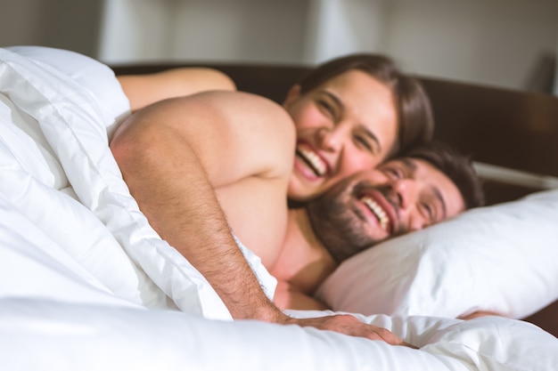 El hombre y la mujer felices yacían en la cama