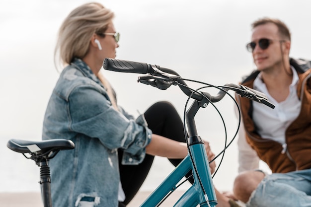 Foto hombre y mujer hablando junto a una bicicleta fuera