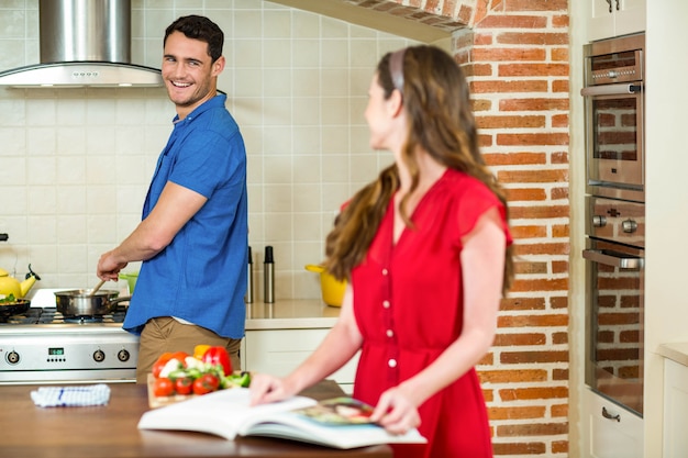 Hombre y mujer hablando juntos mientras trabajan en la cocina en casa