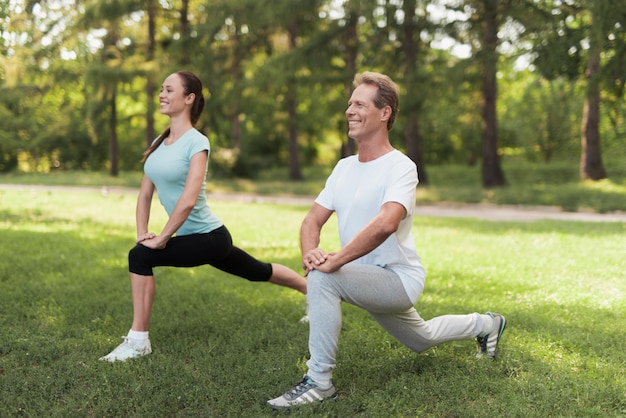 Hombre y mujer haciendo calentamiento en la naturaleza.