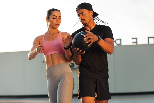 Hombre y mujer haciendo ejercicio con un balón medicinal en el techo