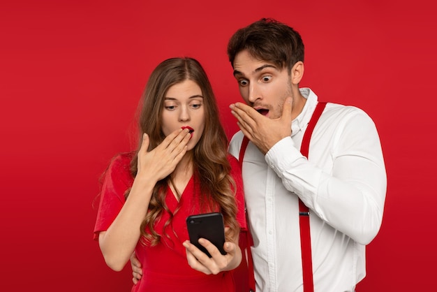 Hombre y mujer hermosa joven abrazan en trajes elegantes tomando selfie