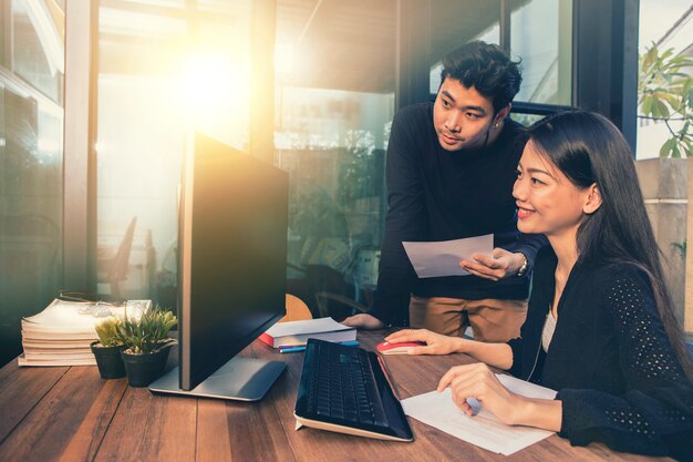 Hombre y mujer independientes jóvenes asiáticos que trabajan en la computadora en la oficina en casa