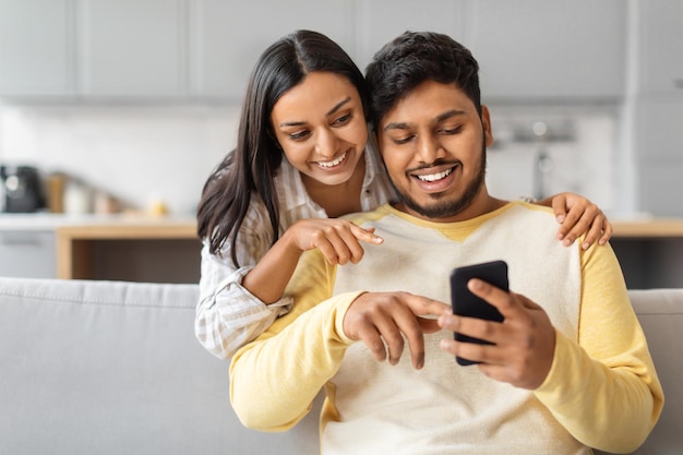 Hombre y mujer indios mirando su teléfono celular.