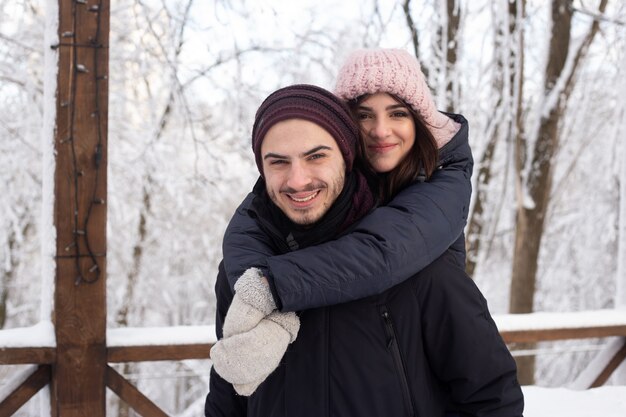 Hombre y mujer joven se divierten al aire libre en invierno antes de Navidad