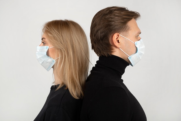 Hombre y mujer joven con mascarillas médicas