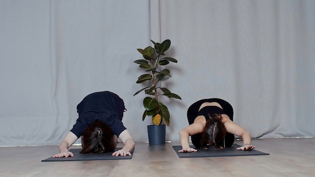 Hombre y mujer jóvenes haciendo yoga en esteras concepto mediático de deporte y cuidado corporal