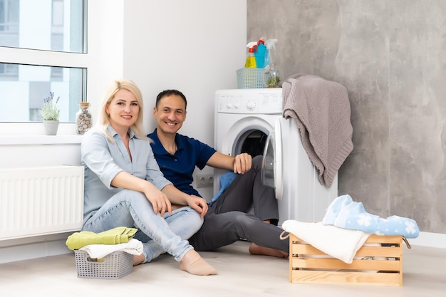 hombre y mujer con lavadora en apartamento