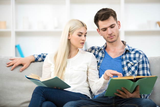 El hombre y la mujer leyendo libros en el sofaj