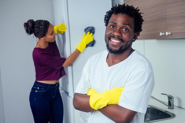 Hombre y mujer limpiando la cocina en casa