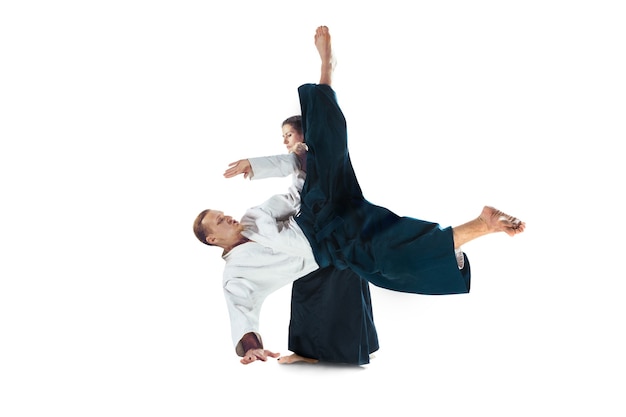 Hombre y mujer luchando y entrenando aikido sobre fondo blanco de estudio