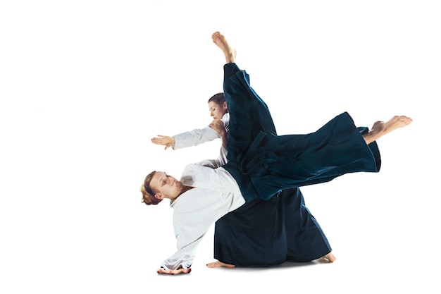 Hombre y mujer luchando y entrenando aikido sobre fondo blanco de estudio