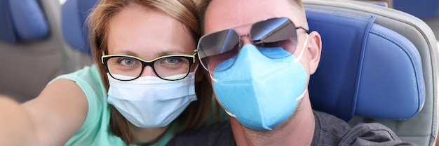 Foto hombre y mujer con máscaras protectoras médicas en avión