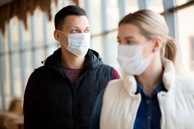 Hombre y mujer con mascarilla médica en el aeropuerto