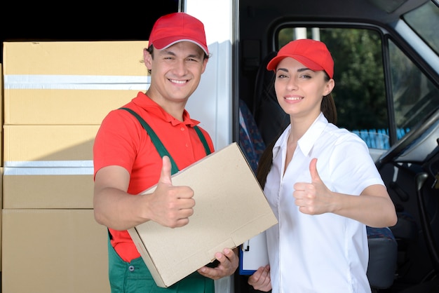 Hombre y mujer mensajero de entrega postal hombre antes de la furgoneta de carga