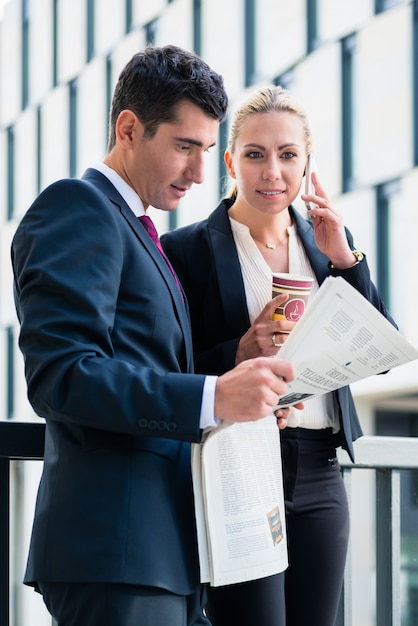 Hombre y mujer de negocios con papel y teléfono